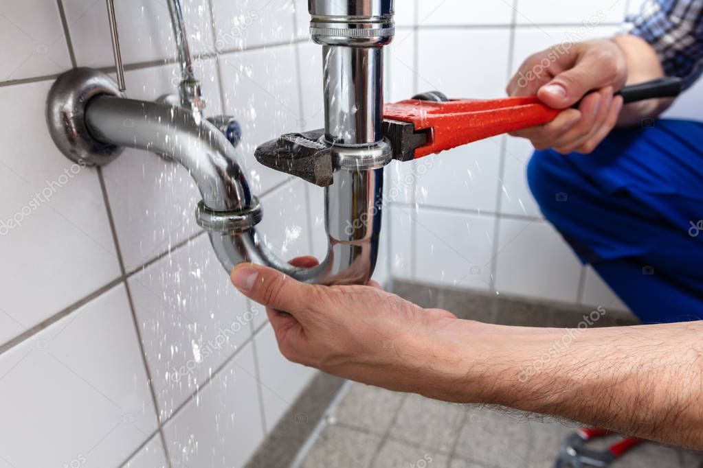 male-plumbers-hand-repairing-sink-pipe-leakage-with-adjustable-wrench-stockpack-deposit-photos-1.jpeg